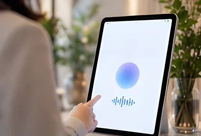 AI受付の音声入力の画面を表示した受付のタブレットに触れる来訪者