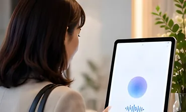 受付のタブレットに話しかける来訪者